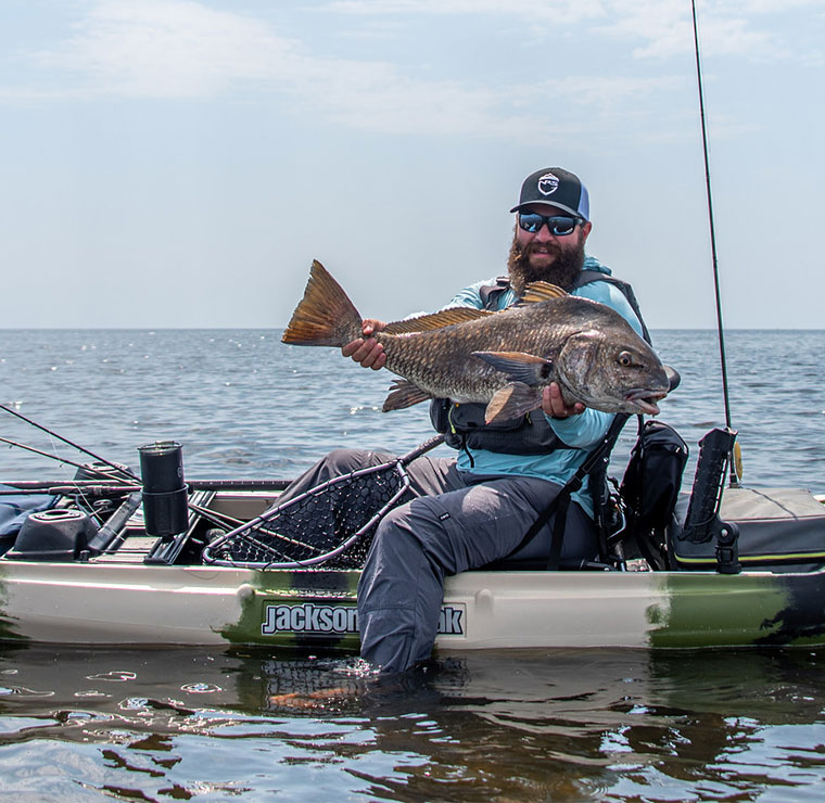 Jameson in a Jackson Kayak Kilroy HD holding a big fish for the camera.